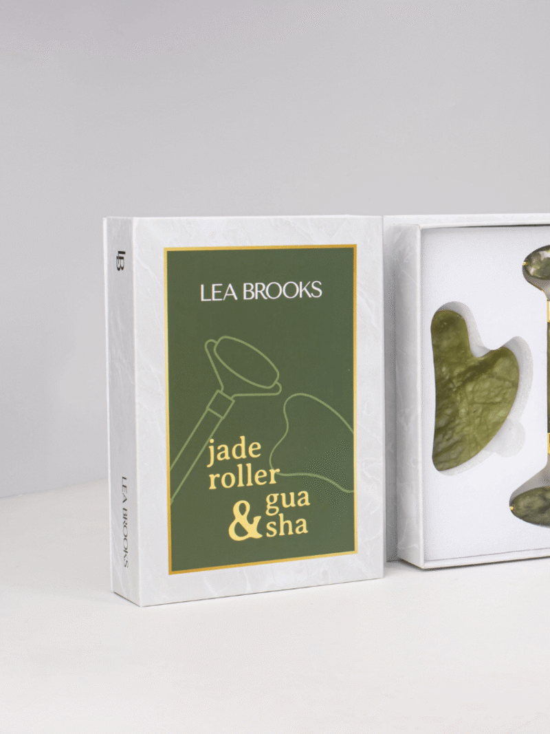 Lea Brooks Jade-Roller und Gua Sha Set in weißer Box mit grünem Etikett und Jade-Werkzeugen