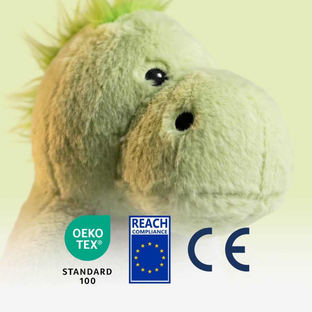 Nahaufnahme des Kopfes eines weichen hellgrünen Drachen-Kuscheltiers mit OEKO-TEX, REACH und CE Zertifizierungslogos
