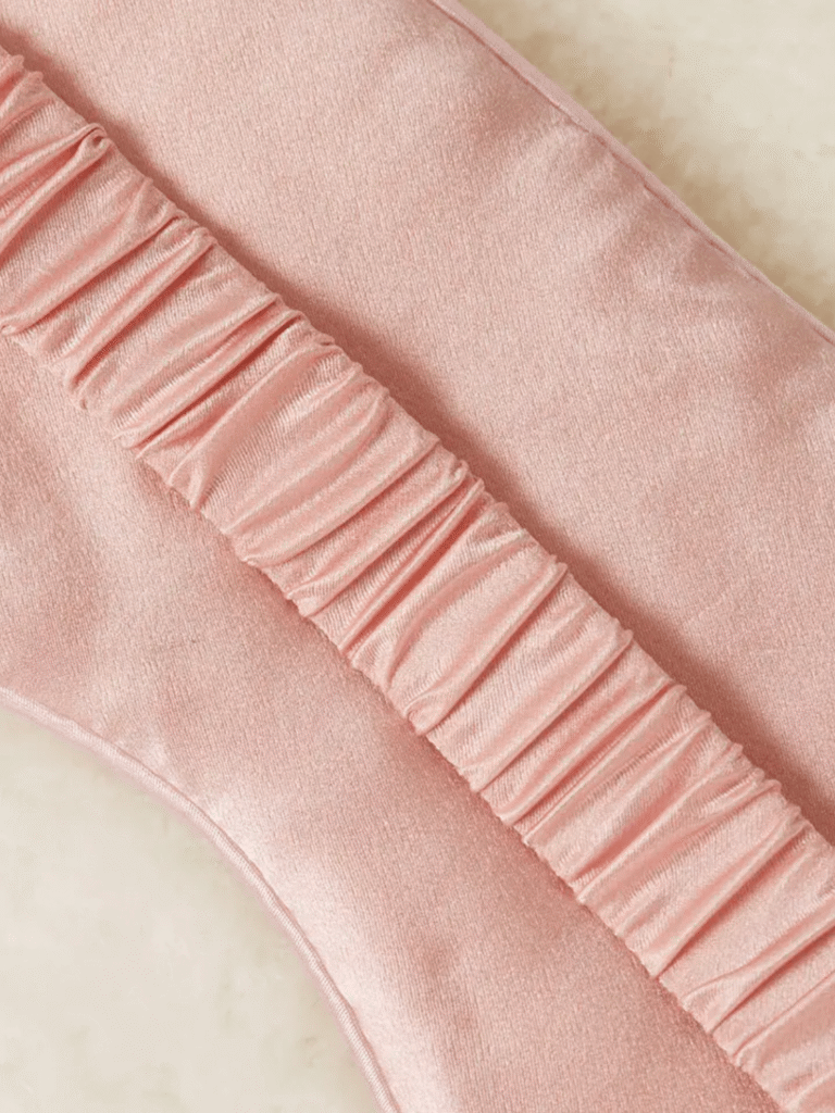 Rosa glänzender Stoff mit diagonal verlaufender, feiner geraffter Rüsche